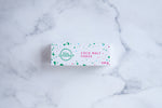 Load image into Gallery viewer, A white box sits on a neutral background. Large hunter green lettering states &#39;fudge&#39; and is surrounded by hunter green and cerise pink paint splashes.
