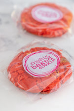 Load image into Gallery viewer, Two red velvet cookies in branded packaging
