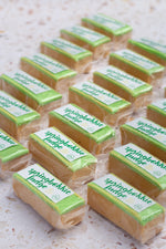 Load image into Gallery viewer, Rows of Springbokkie fudge bars with green and white packaging on a light background
