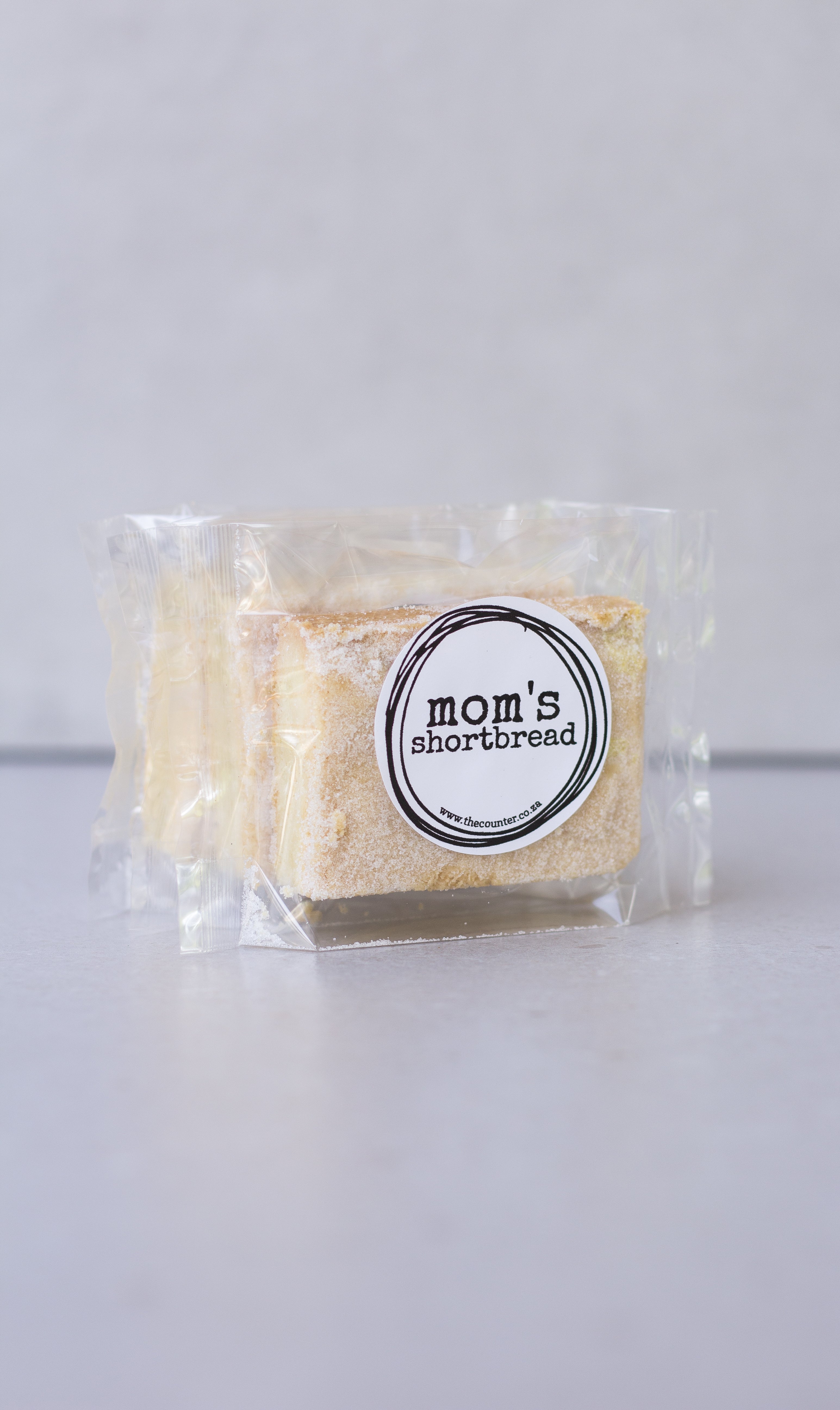 Mom's shortbread - traditional Scottish butter shortbread, packaged in cellophane and finished with a black sticker that says 'Mom's Shortbread'.