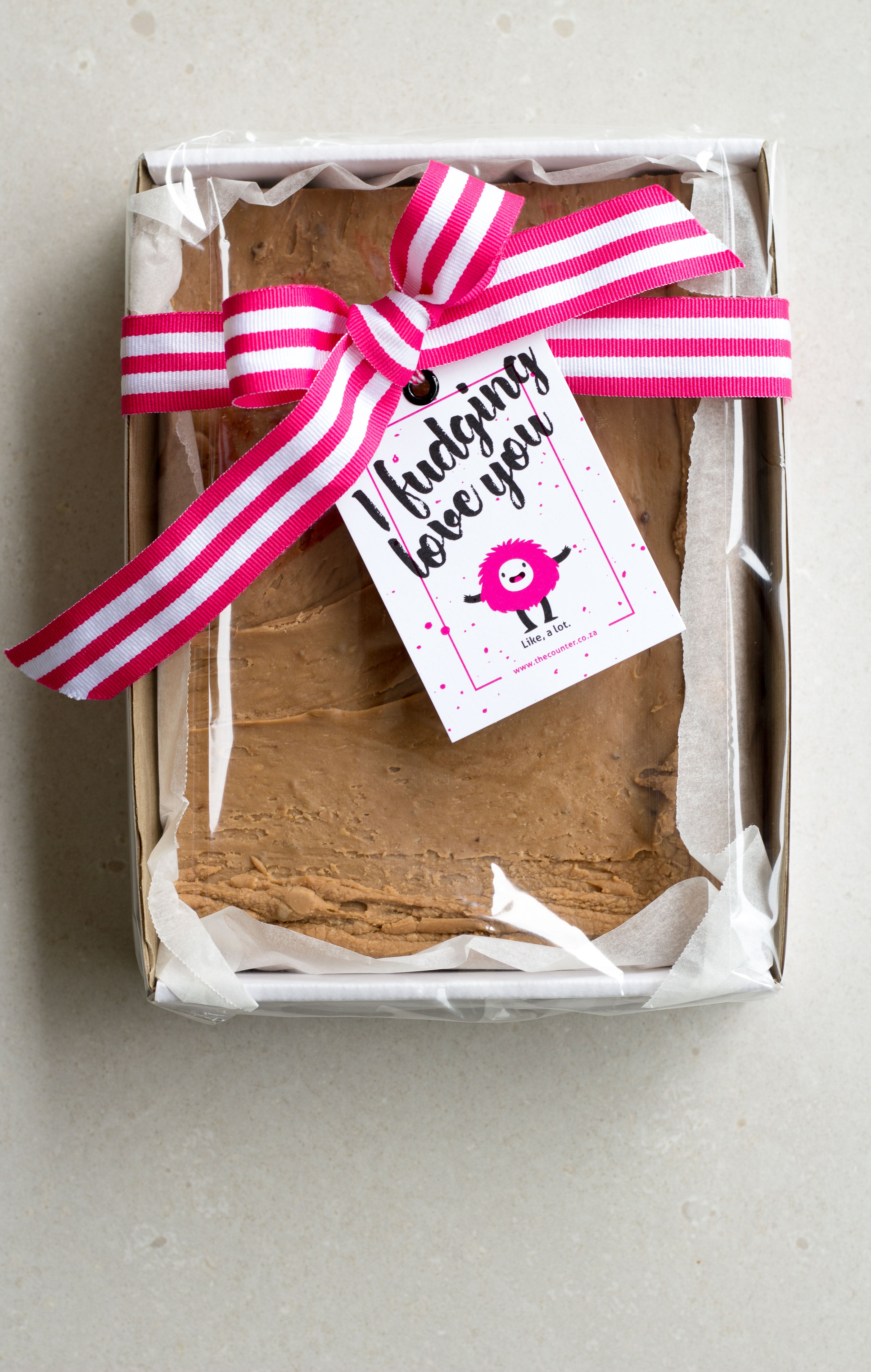 One kilogram Coco Malt fudge slab in a sturdy cardboard tray, finished with a pink striped ribbon and 'I Fudging Love You' swing tag