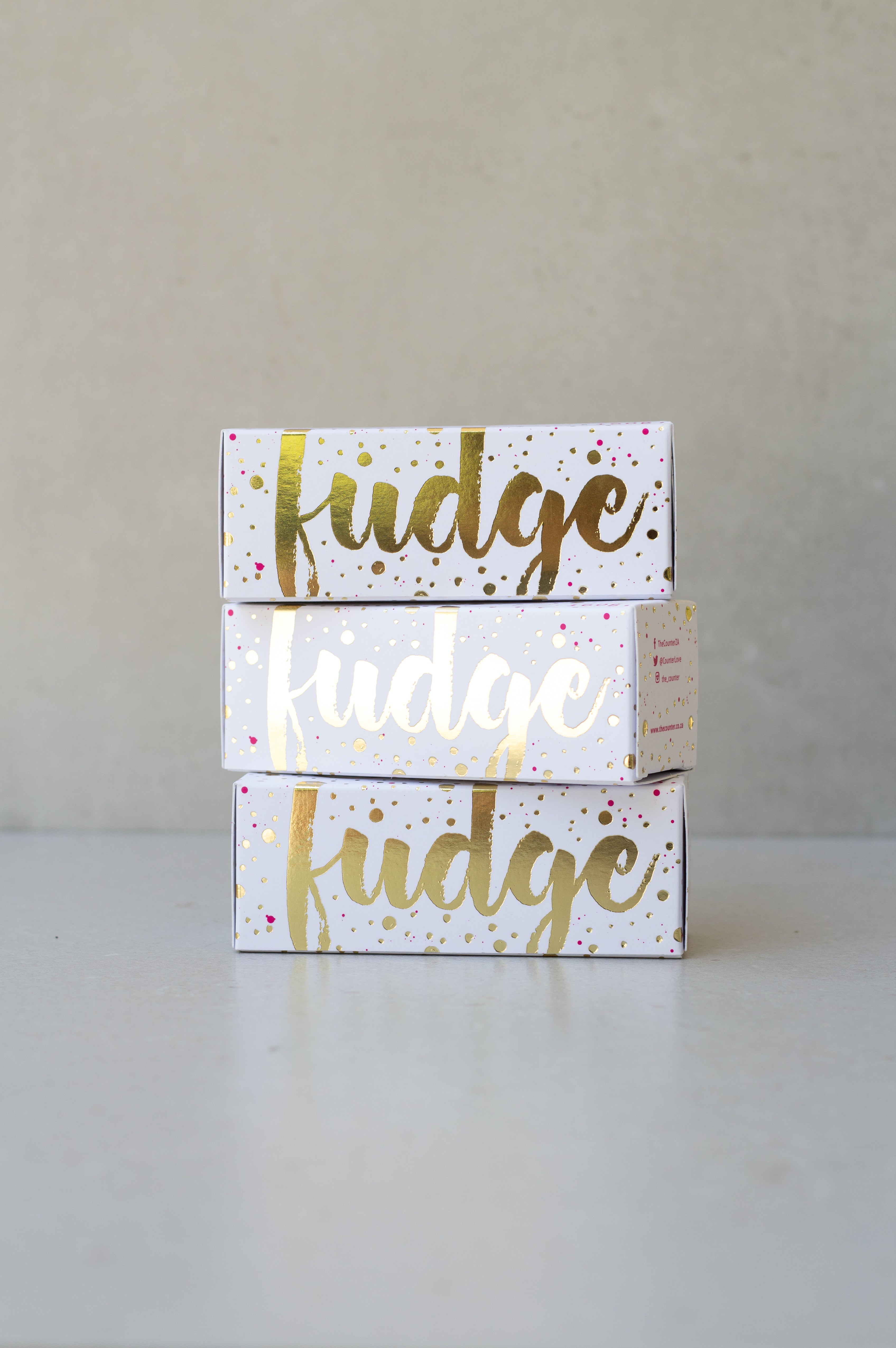 Gold foiled white box filled with gingerbread fudge.