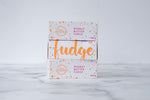Load image into Gallery viewer, Three white boxes are stacked on a neutral background. Paint splashes in orange and pink surround a messy circled logo for The Counter on the first and third box; and the words ‘Peanut Butter Fudge&#39; are written in cerise pink block lettering. The middle box has large, orange cursive writing on it stating &#39;fudge&#39;.
