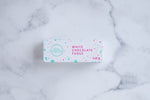 Load image into Gallery viewer, White chocolate fudge box with &#39;The Counter&#39; logo in turquoise, surrounded by several thin lines creating a circle. Pink text stating &#39;white chocolate fudge&#39; and paint splashes surrounding the text and logo.
